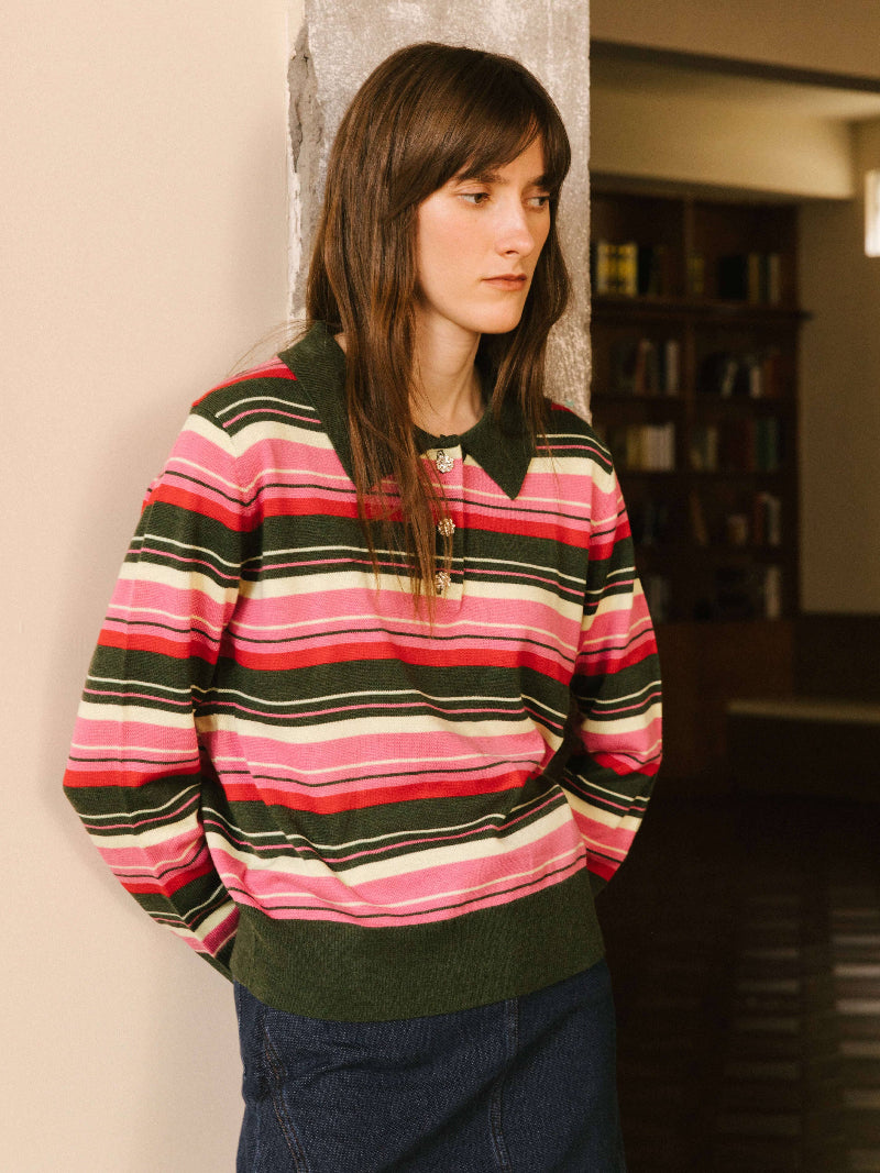 Person wearing a colorful striped sweater in an indoor setting