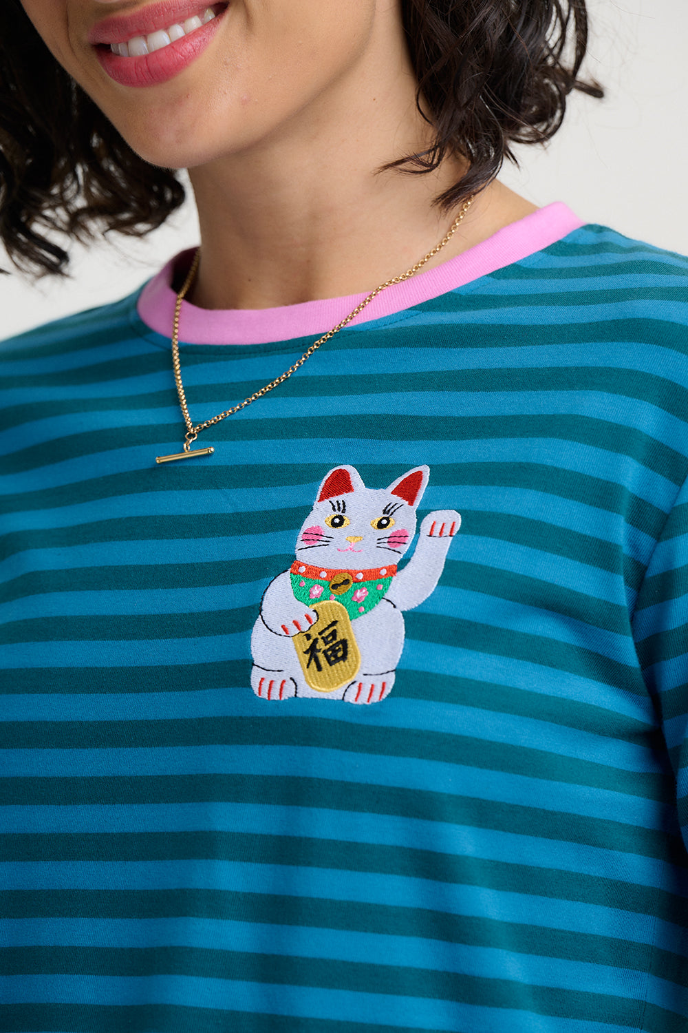 Person wearing a Sugarhill Brighton Brunswick Lucky Cat Jersey Top blue striped shirt 
