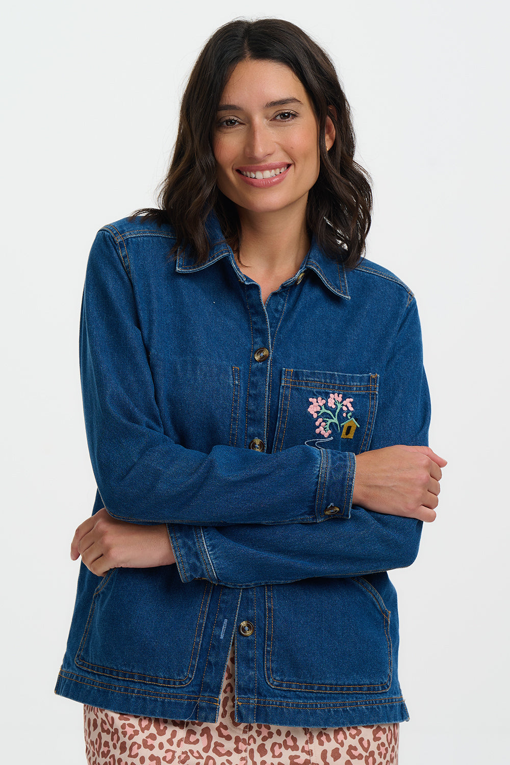 Woman wearing a Sugarhill Dita Denim Jacketwith floral embroidery on a white background