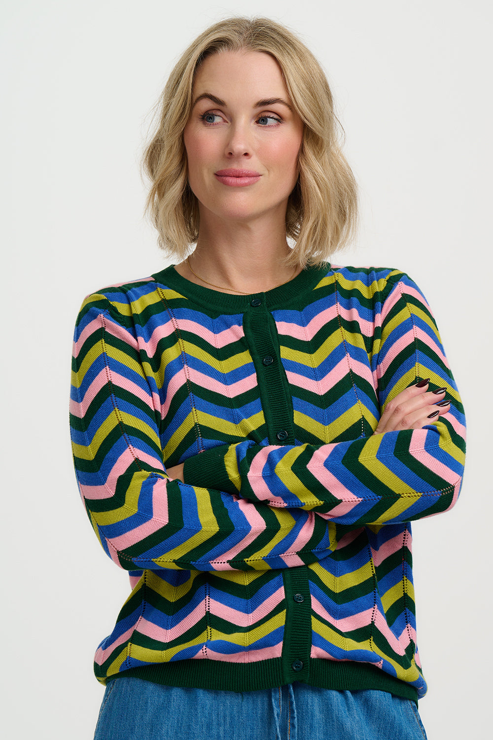 Woman wearing a colorful zigzag pattern sweater on a white background