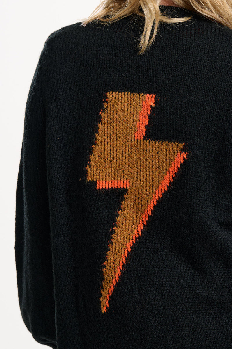 Black sweater with a brown and red lightning bolt design on the back.