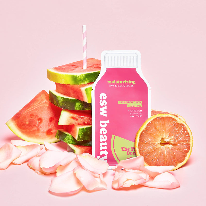 Pink bottle labeled 'esw beauty' with watermelon slices and a grapefruit on a pink background