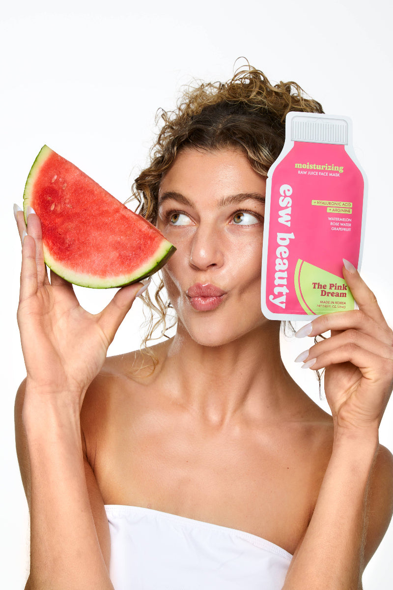 Woman holding a watermelon slice and a pink skincare product with 'esw beauty' branding.