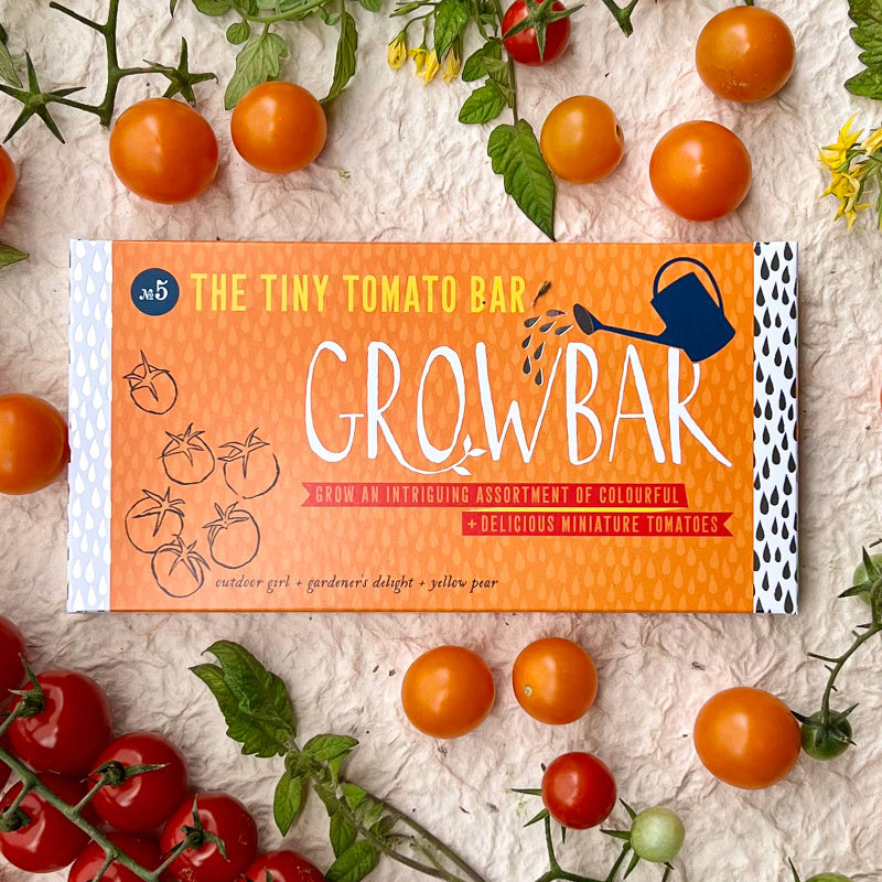 Grow bar packaging for The Tiny Tomato Bar with tomatoes and plant leaves around.