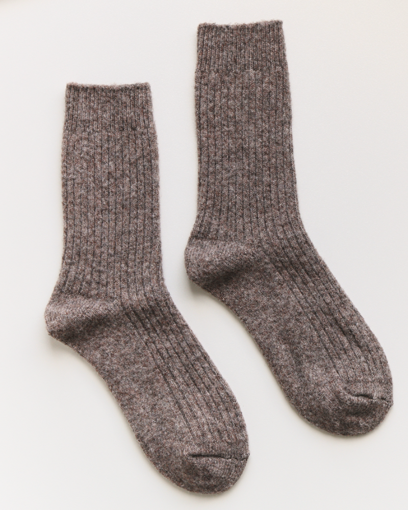 Pair of gray socks on a white background with a label next to them.