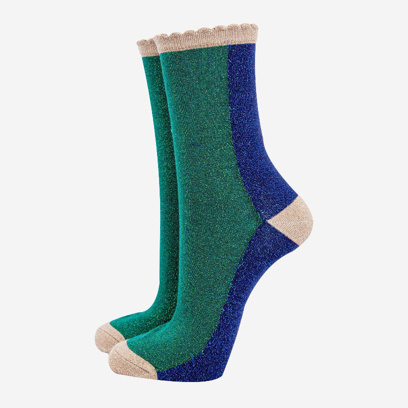 Pair of green and blue socks with beige accents on a white background