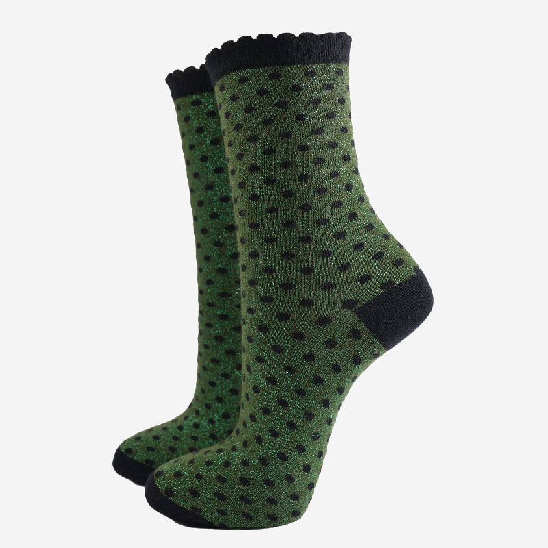 Green socks with black polka dots and cuffs on a white background