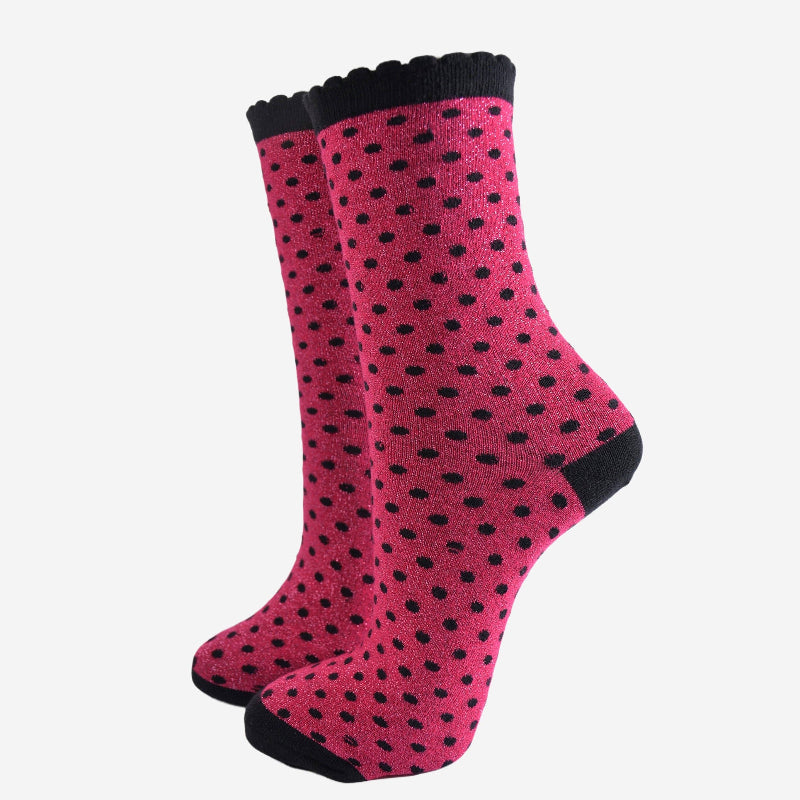Pink socks with black polka dots on a white background