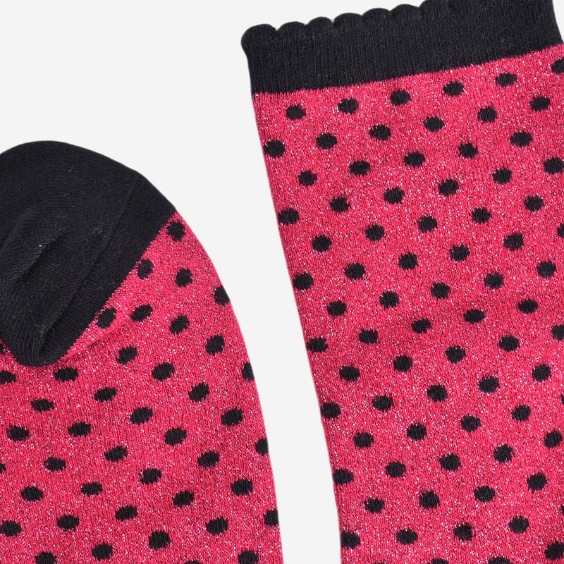 Red socks with black polka dots on a white background