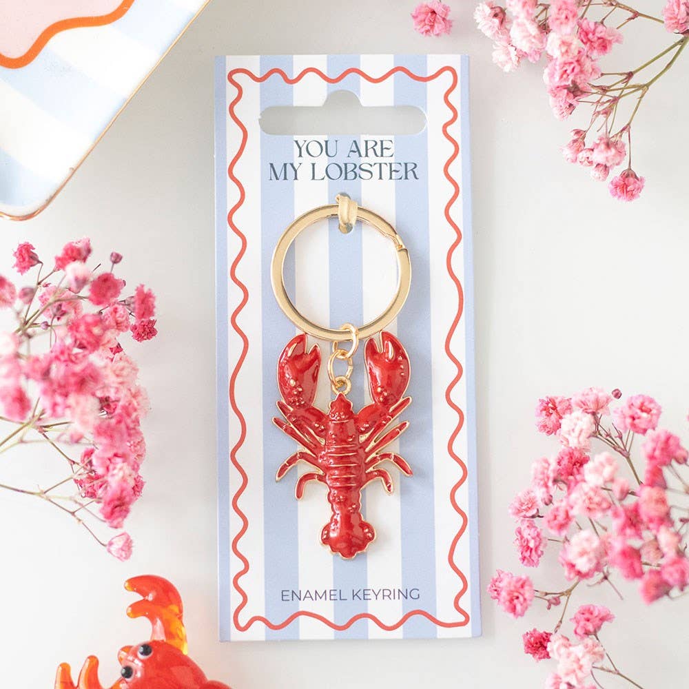 Red lobster keychain on a striped card with flowers around