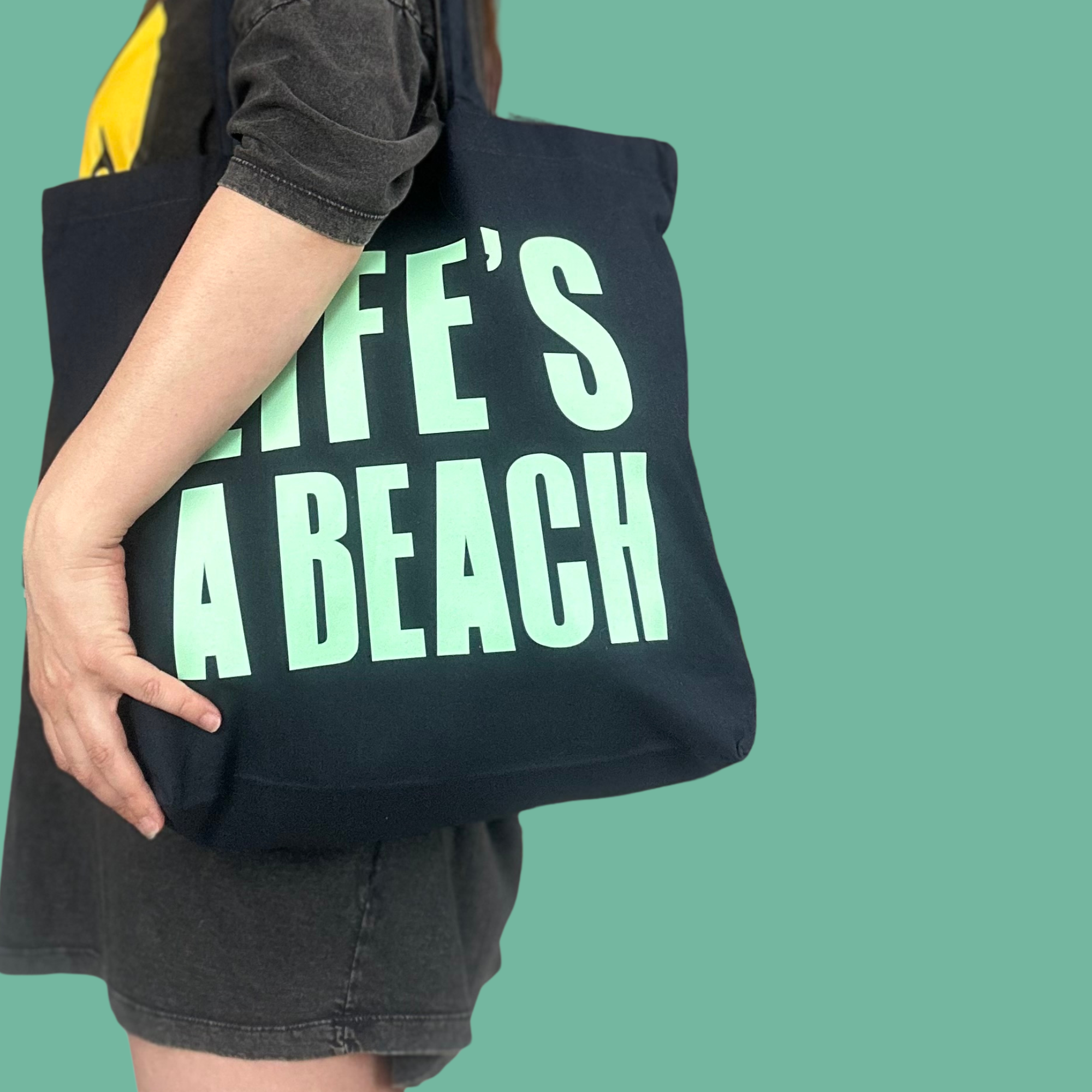 large blue tote bag with 'life's a beach' hand printed in turquoise