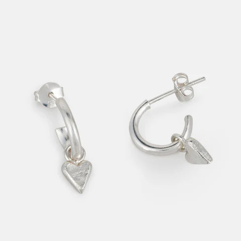 Silver hoop earrings with heart charms on a white background