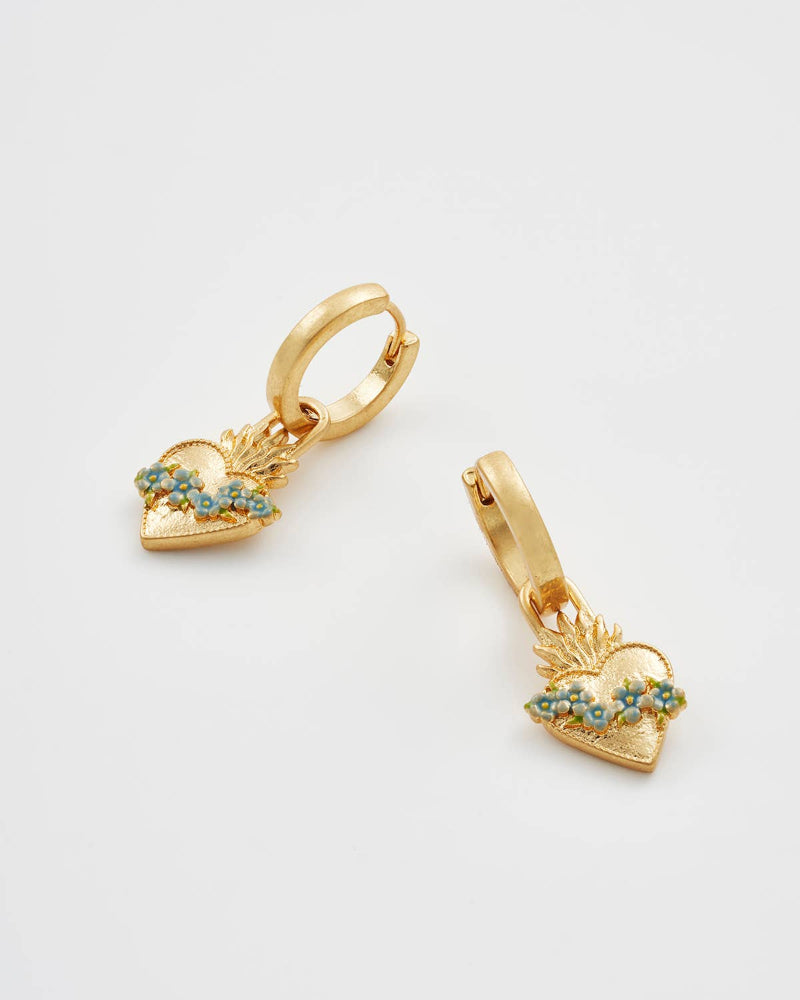 Gold heart-shaped earrings with green gemstones on a light gray background