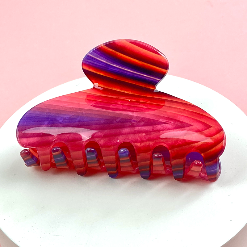 curved hair claw with red and purple banded pattern