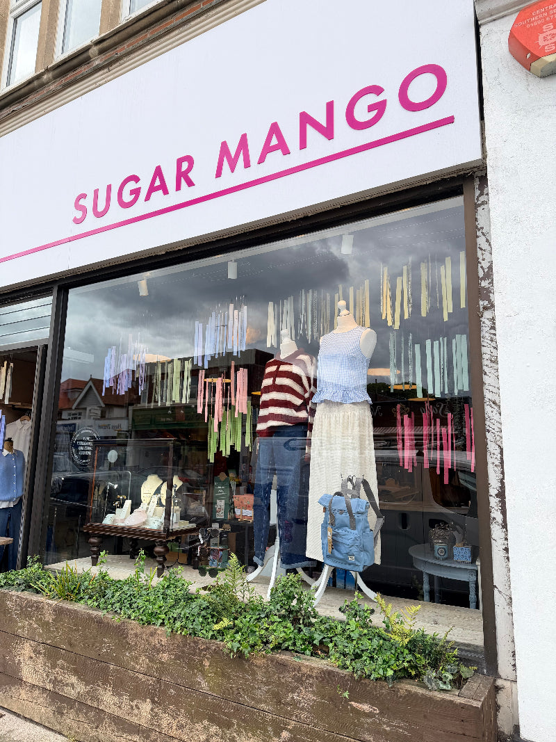 Storefront of Sugar Mango with mannequins and clothing displayed in the window.