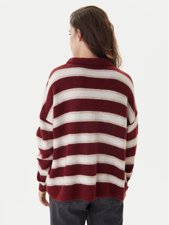 Person wearing a red and white striped sweater on a plain background