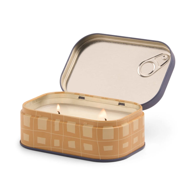 Candle in a decorative tin with a checkered pattern on a white background