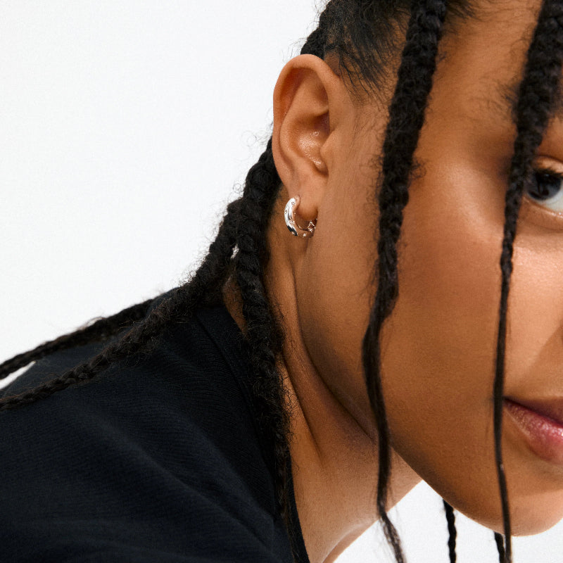 Close-up of a person wearing Pilgrim Nevaeh Earrings Silver-plated with a white background