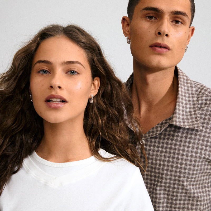 Two wearing Pilgrim Free Earrings Silver-plated people standing close together against a plain background