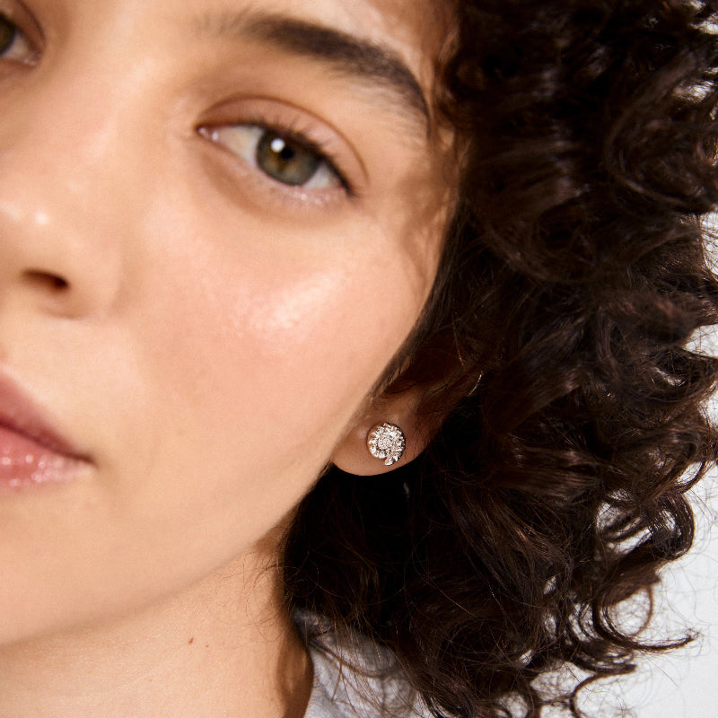 Close-up of a person wearing a pilgrim haze silver studs waterproof with a neutral background