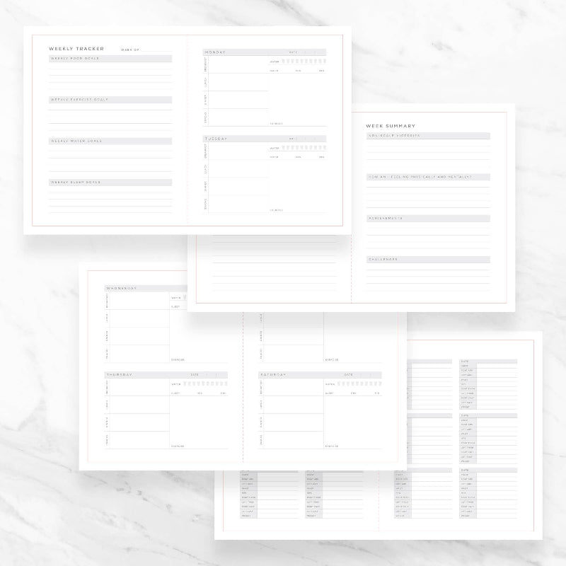 Set of white planner pages on a marble surface