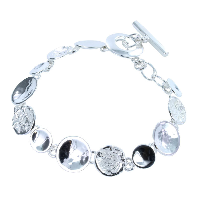 Silver bracelet of textured and smooth discs with toggle clasp