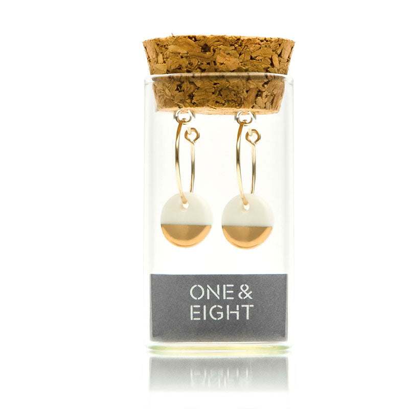 one and eight gold dipped porcelain earrings in bottle